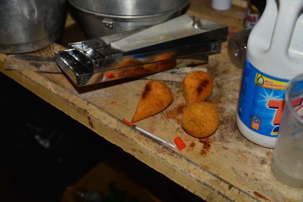 Coxinhas fritas em cima da pia com seringa e cloro (Foto: Divulgação/PMC)